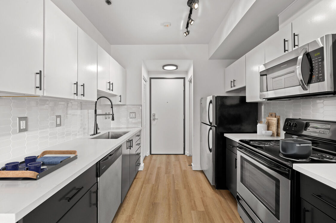 Kitchen with stainless steel appliances and white counters