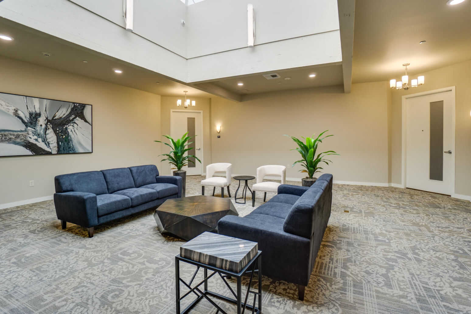 lobby area with two blue couches and 2 white chairs