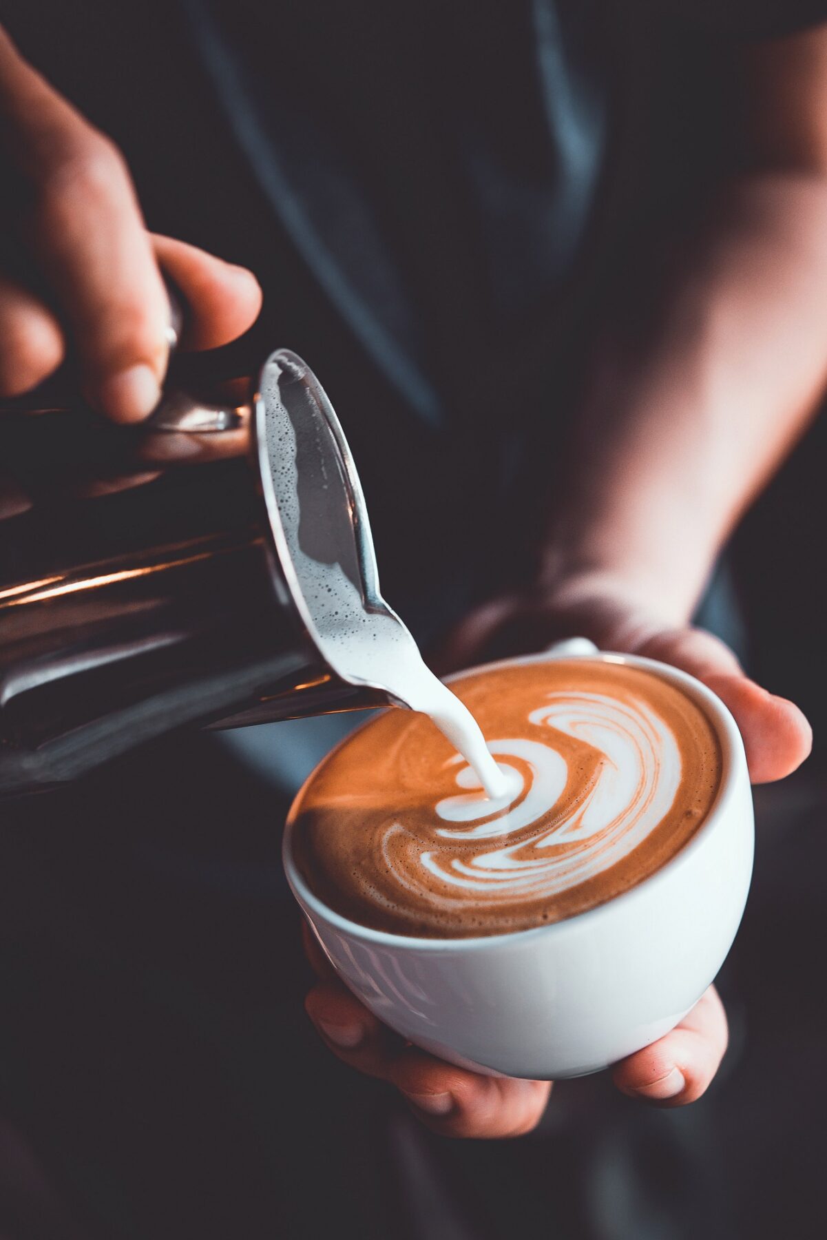 barista pouring a latte