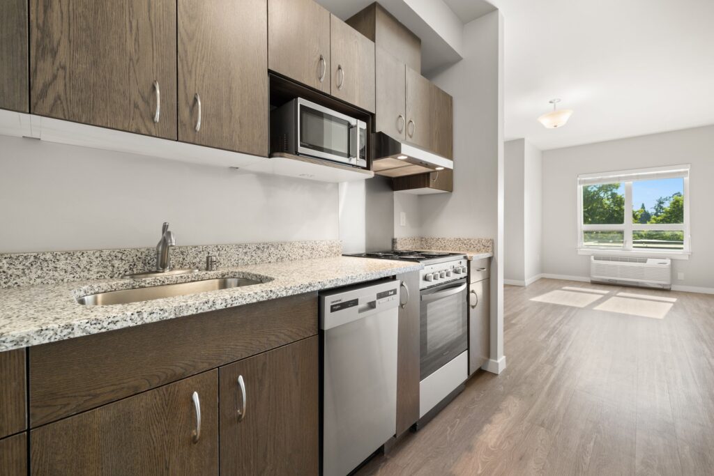 kitchen area with granite countertops, stainless steel appliances, wood-style flooring and open access to the living room