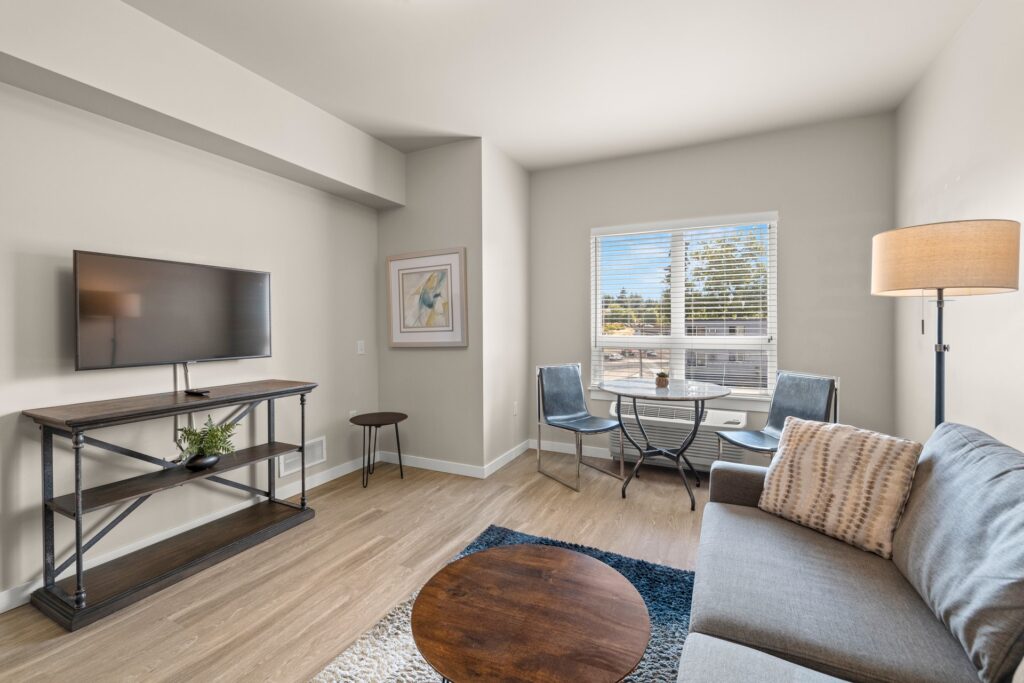 staged living room with large window and dining area